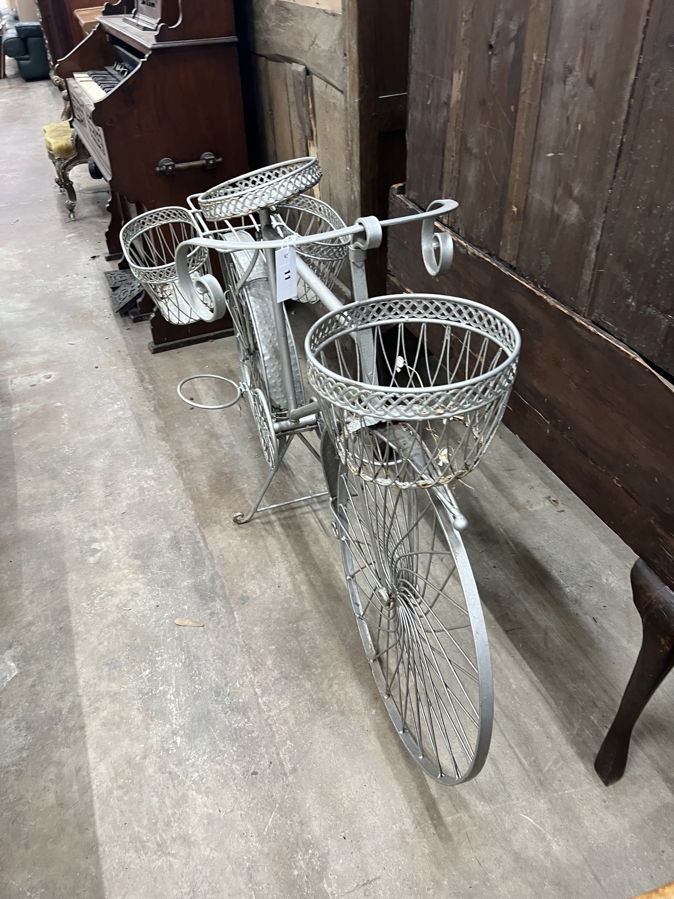 A wrought metal ' Bicycle' garden pot stand, length 144cm, height 90cm